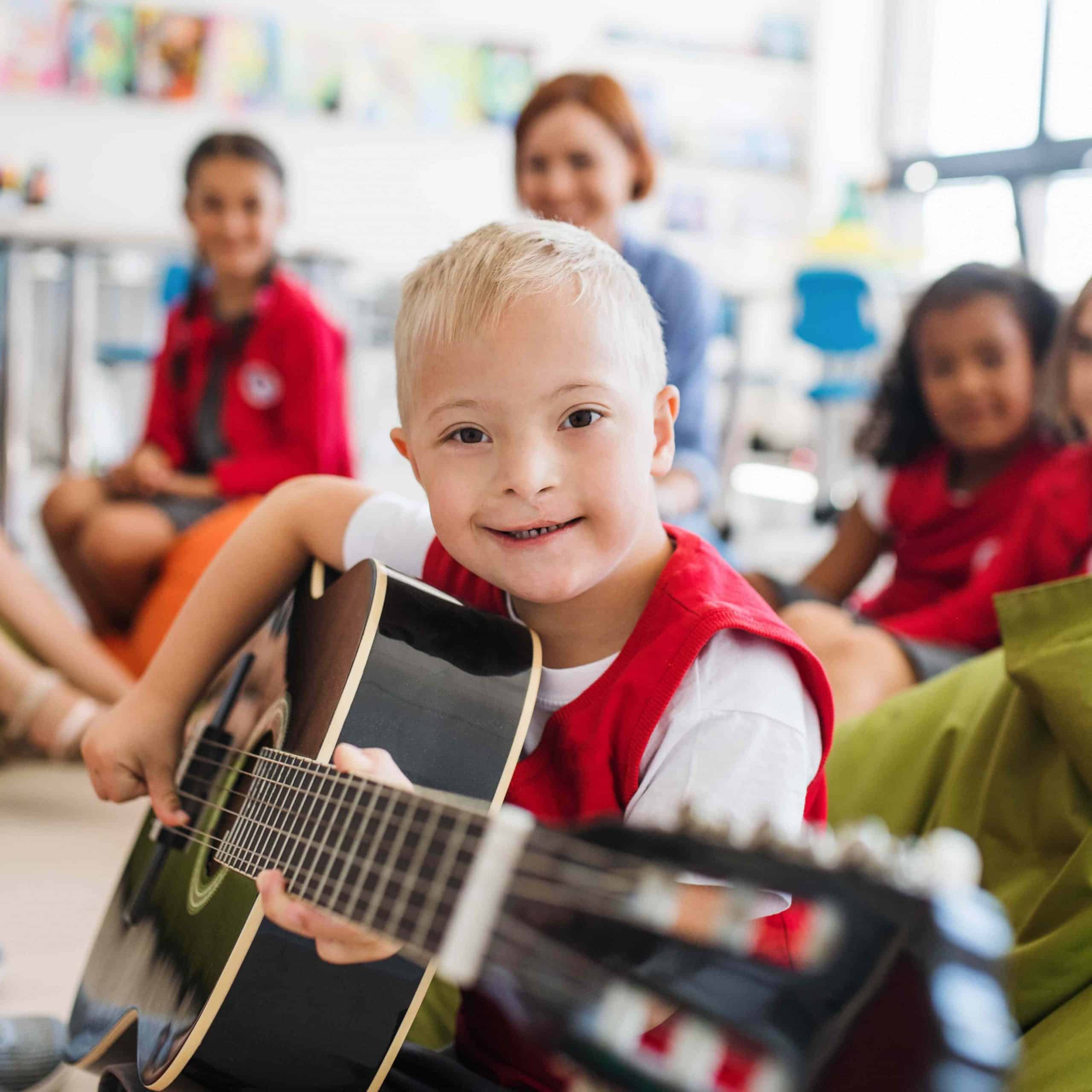 Boy Playing Guitar in Classroom